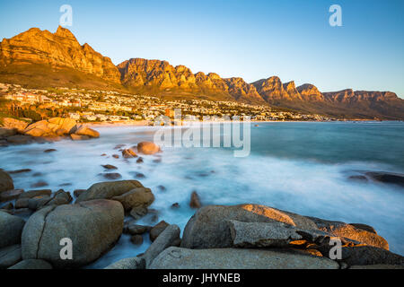 Sonnenuntergang in Camps Bay mit dem Tafelberg auf der linken Seite und die zwölf Apostel auf der rechten Seite, Western Cape, Südafrika Stockfoto