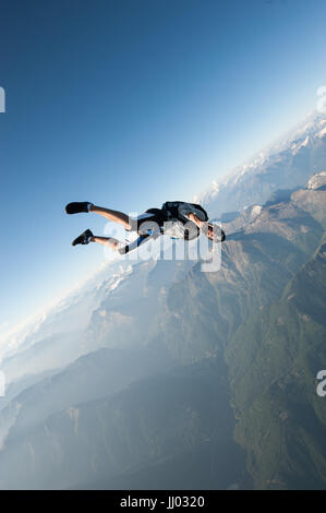 Ein Fallschirmspringer tracking oberhalb Locarno, Schweiz mit den Alpen im Hintergrund Stockfoto