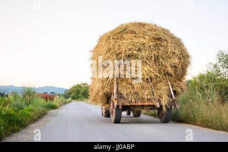 Traktor mit Heu auf der Dorfstraße Stockfoto