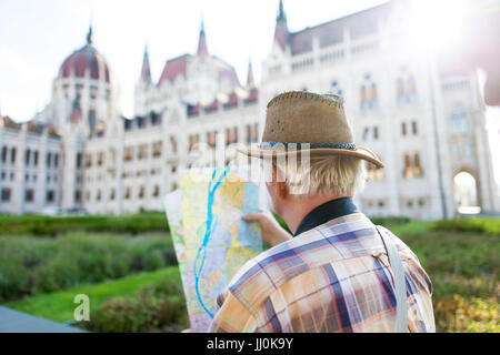 Senior Tourist Mann mit Hut gerade Karte im Parlament, Budapest, Ungarn Stockfoto