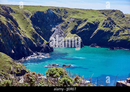 Pfosten-Felsen und das Meer in Mullion Cove, mit einem Teil des Hafens, von der Süd-Westküste Weg, Lizard, Cornwall, UK Stockfoto