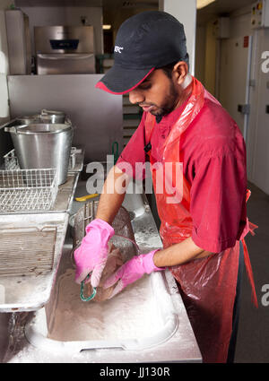 Ein Mitglied des Personals bereitet Brathähnchen bei KFC im England, UK. Stockfoto