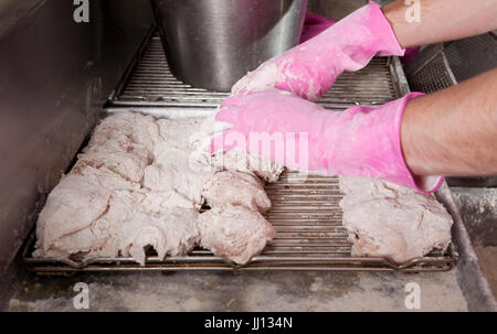 Ein Mitglied des Personals bereitet Brathähnchen bei KFC im England, UK. Stockfoto