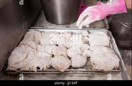 Ein Mitglied des Personals bereitet Brathähnchen bei KFC im England, UK. Stockfoto