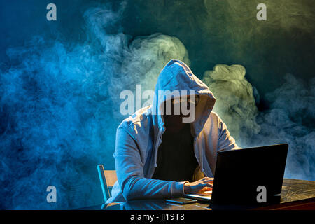 Mit Kapuze Computer-Hacker stehlen Daten mit laptop Stockfoto