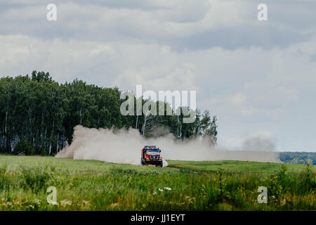 LKW-Rallye-Auto Renault Straßenfahrt Staub zwischen Wald und Rasen während der Silk Way Rallye Stockfoto