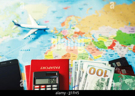 Urlaub-Hintergrund mit Karte, Dollar Geld, Kreditkarten, Handy, Flugzeug, Rechner.  Konzept über billige Reiseziele. Stockfoto