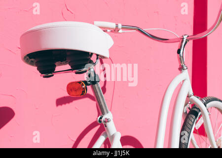 Details der weiblichen urban Fahrrad auf einem Hintergrund von Rosa Wand, Nahaufnahme Stockfoto