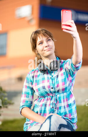 Glückliche junge Wpman die Bilder von sich selbst über Handy. Selfie. Stockfoto