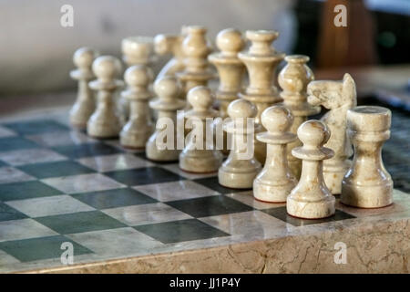 Stein geschnitzte Figuren auf dem Schachbrett. Flachen DOF, Fokus auf Vorderteil. Stockfoto