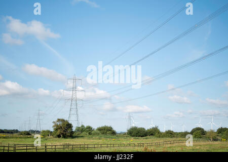 Pylone und Windkraftanlagen Erzeugung und Verteilung von Strom an das nationale Stromnetz. Stockfoto