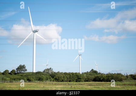 Pylone und Windkraftanlagen Erzeugung und Verteilung von Strom an das nationale Stromnetz. Stockfoto