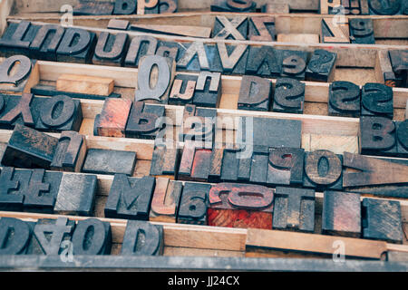 Vintage Schriftsatz Holzbuchstaben in einem Drucker-Tablett auf einem Flohmarkt mit Tinte in einem abstrakten Brief Muster Stockfoto