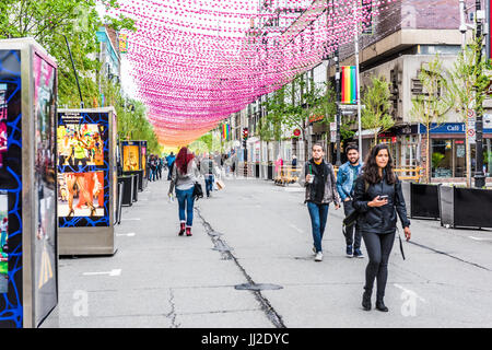 Montreal, Kanada - 26. Mai 2017: Menschen zu Fuß auf Sainte Catherine Street in Montreal Gay Village in Quebec Region mit hängenden Dekorationen Stockfoto