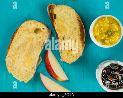 Geschmolzene Käse auf geröstetem Ciabatta-Brot auf blauem Grund aus Holz, Stockfoto