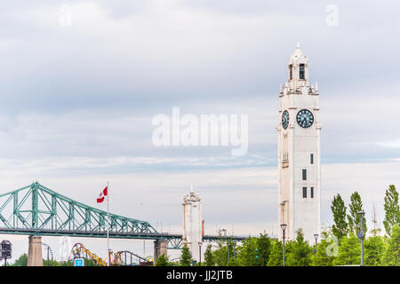 Montreal, Kanada - 27. Mai 2017: Alte Hafengebiet mit Uhrturm isoliert gegen Himmel mit Jacques Cartier Brücke Stockfoto