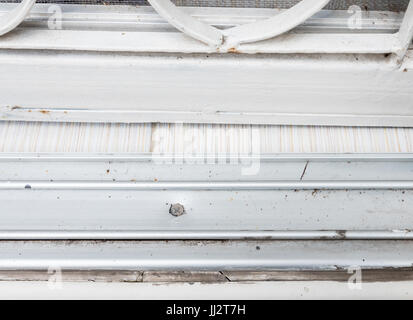 Metallschiene für die Schiebetür aus Glas mit den schmutzigen Fleck hinter dem städtischen Haus. Stockfoto