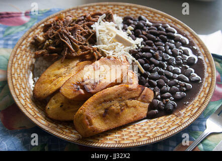 Venezolanische Küche: Pabellón Criollo, Reis, Shredded Rindfleisch, gebratene Kochbananen und geschmorte schwarze Bohnen Stockfoto