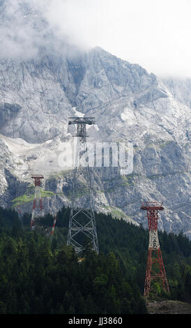 Die neue 127 Meter hohe Stahl-Unterstützung für die neue Seilbahn steht zwischen zwei alten roten stützen, auf der Zugspitze bei Garmisch-Partenkirchen, Deutschland, 17. Juli 2017. Foto: Angelika Warmuth/dpa Stockfoto