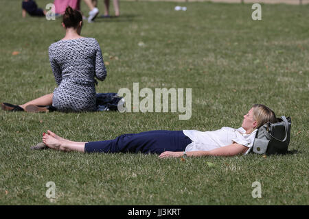 Westminster. London, UK. 18. Juli 2017. Eine Frau sonnt sich an einem warmen und sonnigen Tag im St. James Park als das warme und trockene Wetter setzt sich in der Hauptstadt. Bildnachweis: Dinendra Haria/Alamy Live-Nachrichten Stockfoto