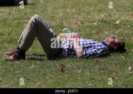 Westminster. London, UK. 18. Juli 2017. Ein Mann sonnt sich an einem warmen und sonnigen Tag im St. James Park als das warme und trockene Wetter setzt sich in der Hauptstadt. Bildnachweis: Dinendra Haria/Alamy Live-Nachrichten Stockfoto