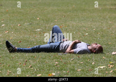 Westminster. London, UK. 18. Juli 2017. Ein Mann sonnt sich an einem warmen und sonnigen Tag im St. James Park als das warme und trockene Wetter setzt sich in der Hauptstadt. Bildnachweis: Dinendra Haria/Alamy Live-Nachrichten Stockfoto