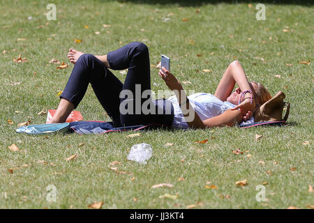 Westminster. London, UK. 18. Juli 2017. Eine Frau sonnt sich an einem warmen und sonnigen Tag im St. James Park als das warme und trockene Wetter setzt sich in der Hauptstadt. Bildnachweis: Dinendra Haria/Alamy Live-Nachrichten Stockfoto