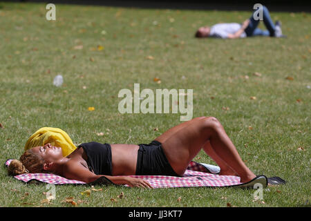 Westminster. London, UK. 18. Juli 2017. Eine Frau sonnt sich an einem warmen und sonnigen Tag im St. James Park als das warme und trockene Wetter setzt sich in der Hauptstadt. Bildnachweis: Dinendra Haria/Alamy Live-Nachrichten Stockfoto