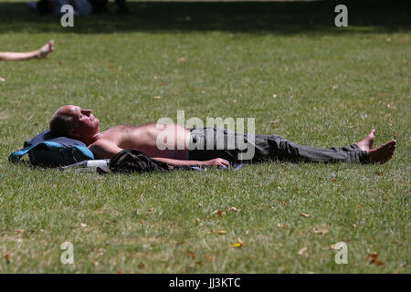 Westminster. London, UK. 18. Juli 2017. Ein Mann sonnt sich an einem warmen und sonnigen Tag im St. James Park als das warme und trockene Wetter setzt sich in der Hauptstadt. Bildnachweis: Dinendra Haria/Alamy Live-Nachrichten Stockfoto