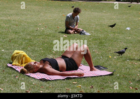 Westminster. London, UK. 18. Juli 2017. Eine Frau sonnt sich an einem warmen und sonnigen Tag im St. James Park als das warme und trockene Wetter setzt sich in der Hauptstadt. Bildnachweis: Dinendra Haria/Alamy Live-Nachrichten Stockfoto