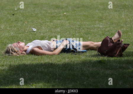 Westminster. London, UK. 18. Juli 2017. Eine Frau sonnt sich an einem warmen und sonnigen Tag im St. James Park als das warme und trockene Wetter setzt sich in der Hauptstadt. Bildnachweis: Dinendra Haria/Alamy Live-Nachrichten Stockfoto