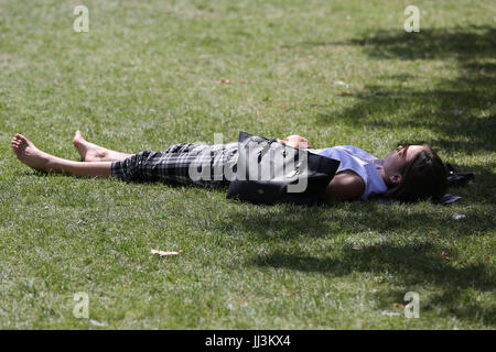 Westminster. London, UK. 18. Juli 2017. Eine Frau sonnt sich an einem warmen und sonnigen Tag im St. James Park als das warme und trockene Wetter setzt sich in der Hauptstadt. Bildnachweis: Dinendra Haria/Alamy Live-Nachrichten Stockfoto