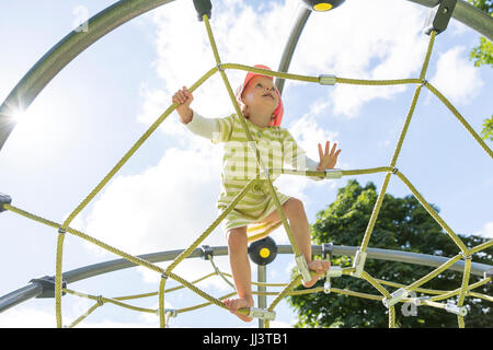 Kleinkind auf Klettergerüst auf einem Spielplatz, Deutschland Stockfoto