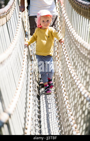 Kleinkind auf einer Hängebrücke auf einem Spielplatz, Deutschland Stockfoto
