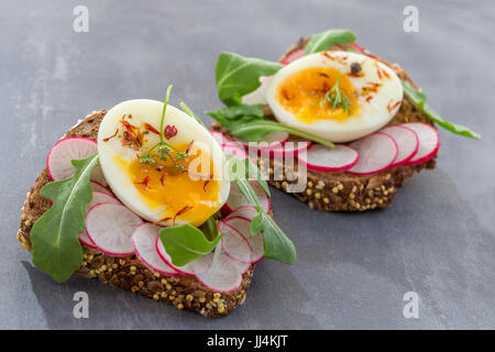 Ein herzhaftes Vollkorn-Sandwich mit Rucola, Radieschen und Eiern Stockfoto