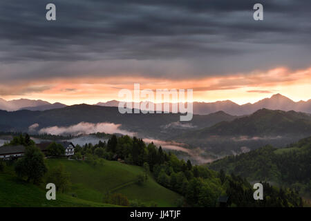 Sonnenaufgang mit Nebel über den Bergen von Kamnik Savinja Alpen mit Storzic Spitze rechts im Skofjelosko Hügel in der Nähe von Ljubljana Slowenien Stockfoto