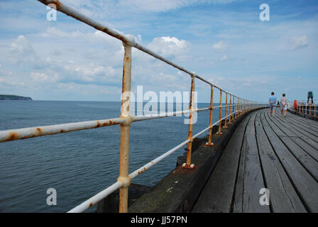 Menschen zu Fuß entlang Whitby Pier West, North Yorkshire Großbritannien Küstenstadt. Genommen Juli 2017 Stockfoto