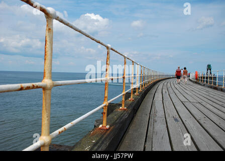 Menschen zu Fuß entlang Whitby Pier West, North Yorkshire Großbritannien Küstenstadt. Genommen Juli 2017 Stockfoto