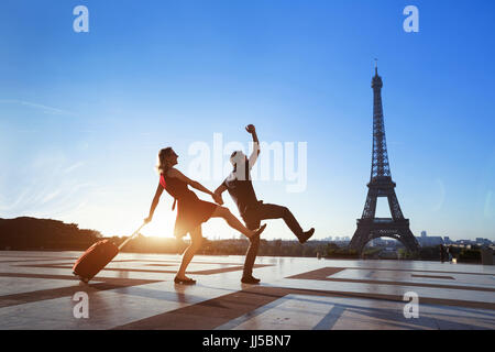 paar verrückte Touristen im Urlaub in Paris, Mann und Frau, die Spaß in der Nähe von Eiffelturm, Reisen mit Gepäck, Tourismus Stockfoto