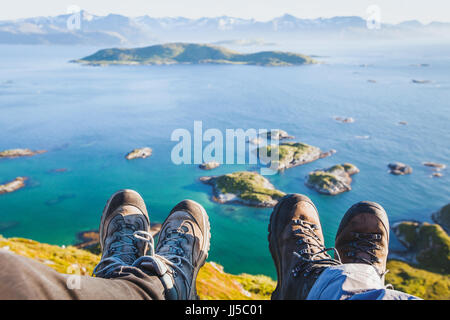 Trekking Schuhe an den Füßen von den Paaren der reisende Wanderer auf dem Gipfel des Berges in Norwegen sitzen mit der schönen Aussicht, Trekker selfy mit norwegischen l Stockfoto