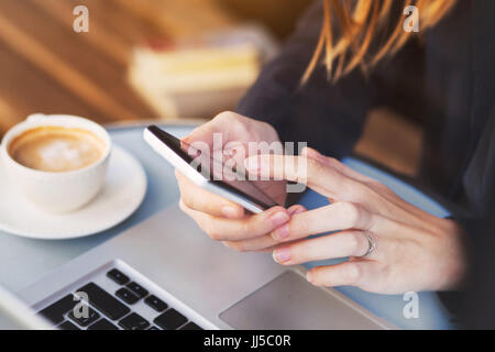 Nahaufnahme von Händen mit mobilen Anwendung auf Smartphone, Frau e-Mails auf ihrem Smartphone im café Stockfoto