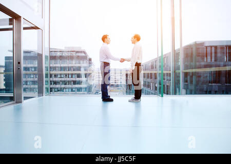 Die Zusammenarbeit von Unternehmen Konzept, Zusammenarbeit, zwei Geschäftsleute die Hände schütteln im Innenraum Stockfoto