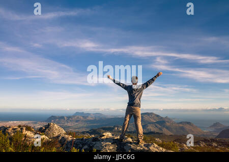 Mann stand mit erhobenen Händen auf den Tafelberg in Kapstadt, Südafrika Stockfoto