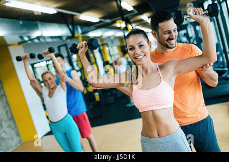 Schöne Frauen, die Übungen im Fitnessraum mit personal Trainer Stockfoto