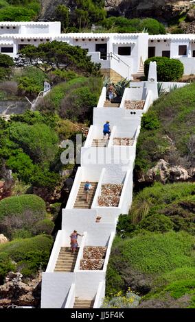 Menschen, die zu Fuß hinauf Schritte Cala Morell Menorca Menorca Spanien Stockfoto