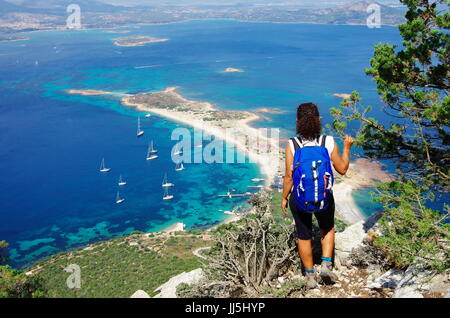 Weibliche Wanderer (junge Erwachsene) auf dem Weg zum Gipfel des Tavolara, Lookng hinunter in Richtung Meer. Stockfoto