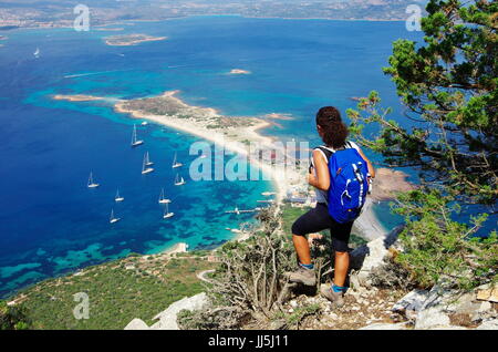 Weibliche Wanderer (junge Erwachsene) auf dem Weg zum Gipfel des Tavolara, Lookng hinunter in Richtung Meer. Stockfoto