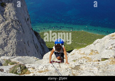 Weibliche Wanderer (junge Erwachsene) auf dem Weg zum Gipfel des Tavolara, Lookng hinunter in Richtung Meer. Stockfoto