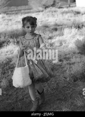 Schwarz / weiß Foto von kleinen Mädchen tragen ein Tutu und Cowboy-Stiefel auf ein Easter Egg hunt Stockfoto