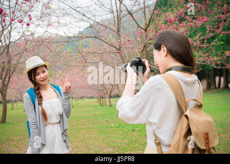 Freunde fotografieren Spaß Lebensstil genießen Kirschblüten in Sakura Park outdoor-Aktivität suchen. Asiatische Frau Foto fotografieren mit cam Stockfoto